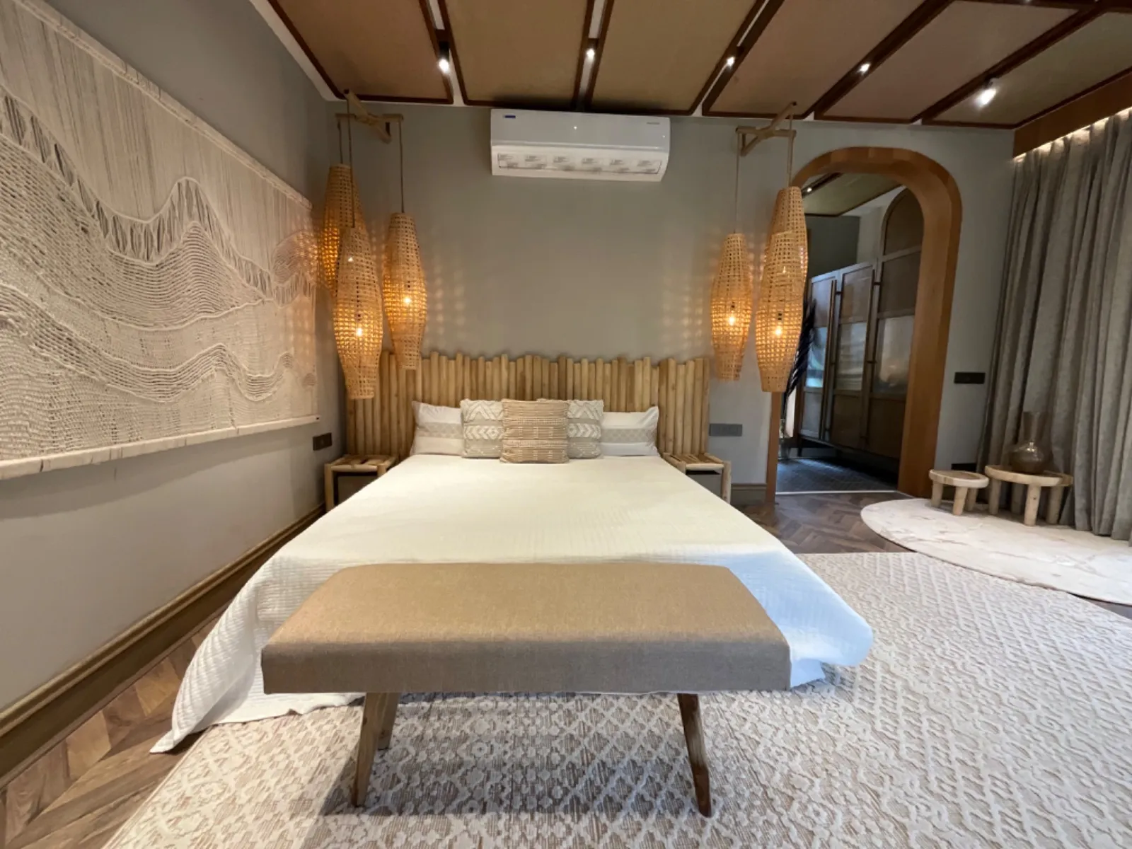 Master bedroom with a floating oak bed, linen drapery and soft cove lighting